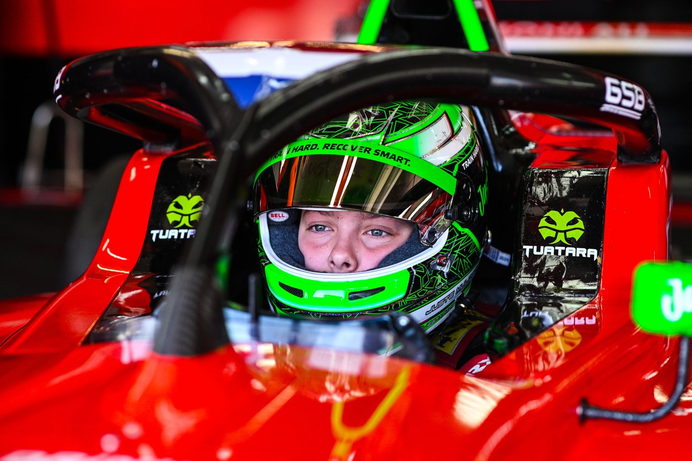 Juste Mulder in de cockpit, met de logo's van zijn partners in beeld