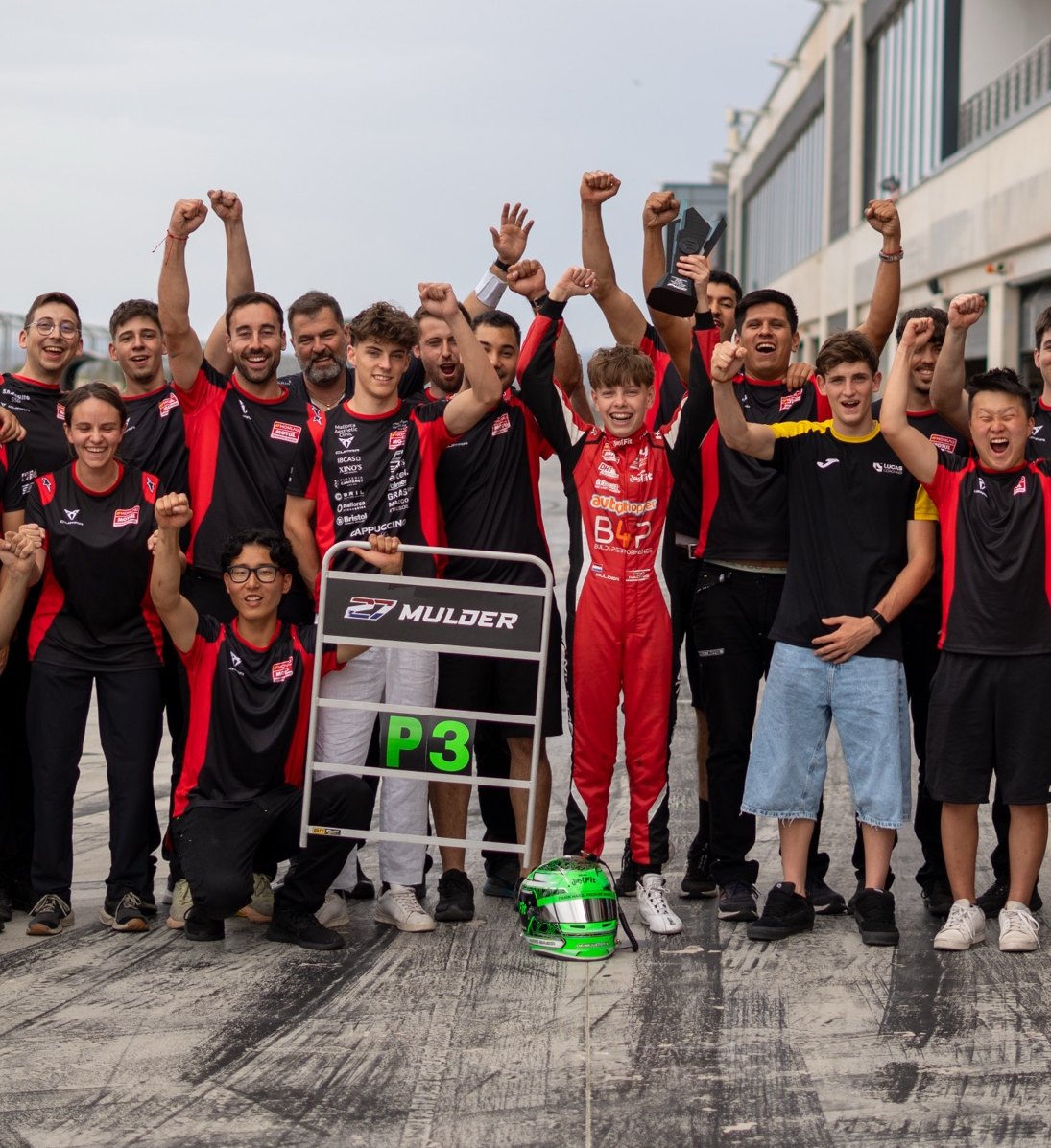 Juste Mulder met het team van Monlau Motorsport na een podiumplaats