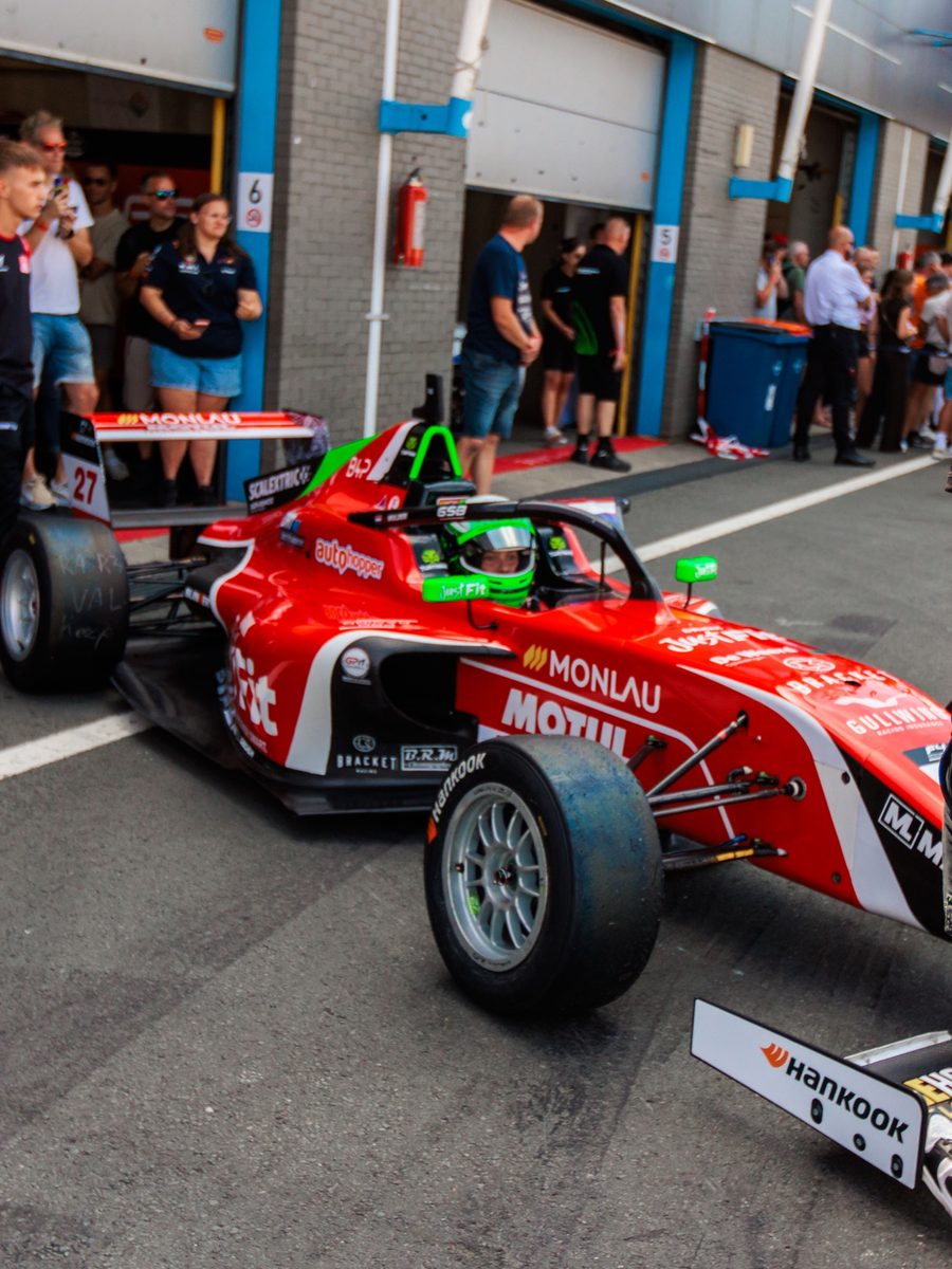De Formule 4-auto in de pitlane met publiek langs de kant